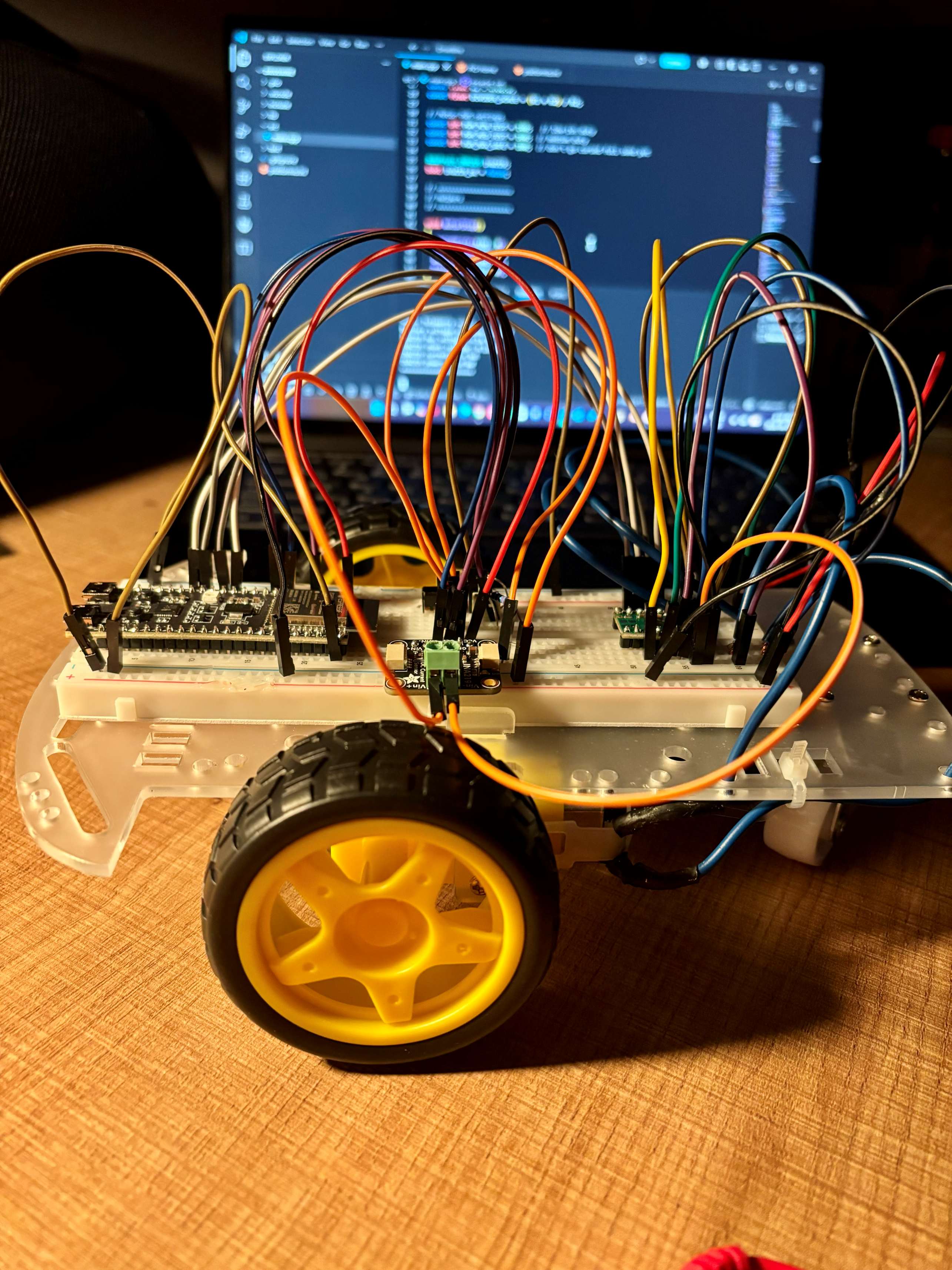 DriveWire bench prototype wired on a chassis in front of firmware code